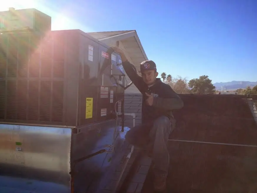 HVAC technician performing AC Tune-Up on a rooftop unit in Edgerton